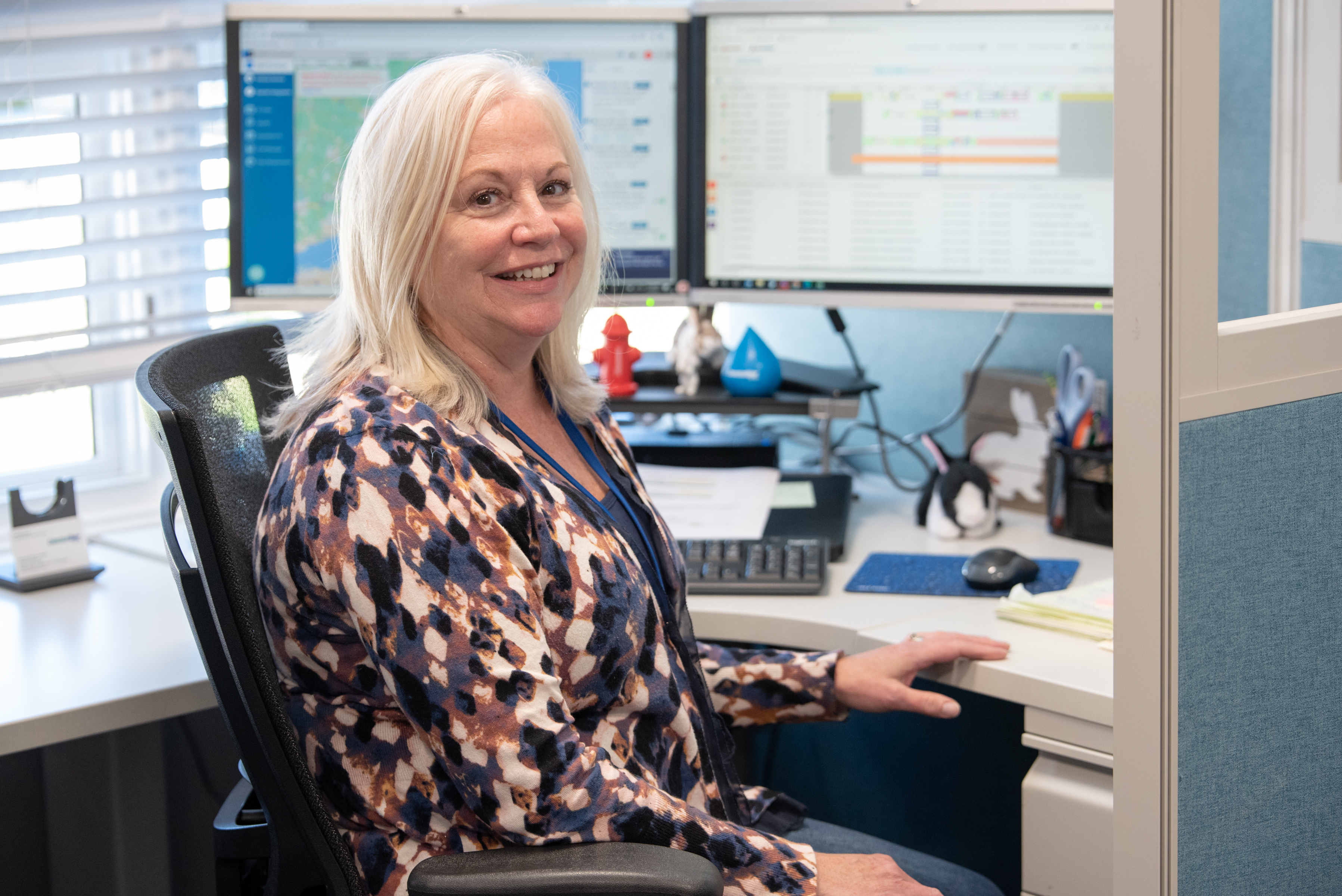 CT water employee in front of their desk looking at the camera and smiling