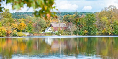 body of water with a red barn in the background